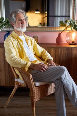 Düşünceli hayalperest adam evde pencerenin önünde oturur, tefekkür eder