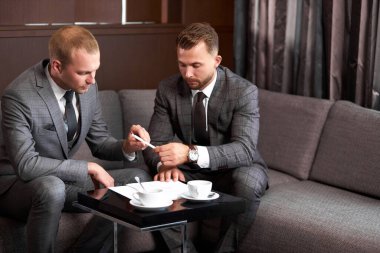 İki Kafkasyalı iş adamı oturup fikir alışverişinde bulunuyor.