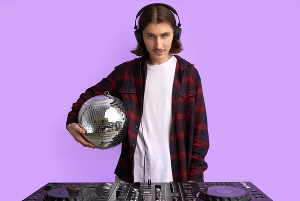 Snygg DJ hane med en mixer utrustning för att styra ljud och spela musik — Stockfoto