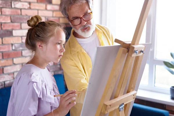 Persoonlijke kunst leraar leren klein meisje om te tekenen op ezel — Stockfoto