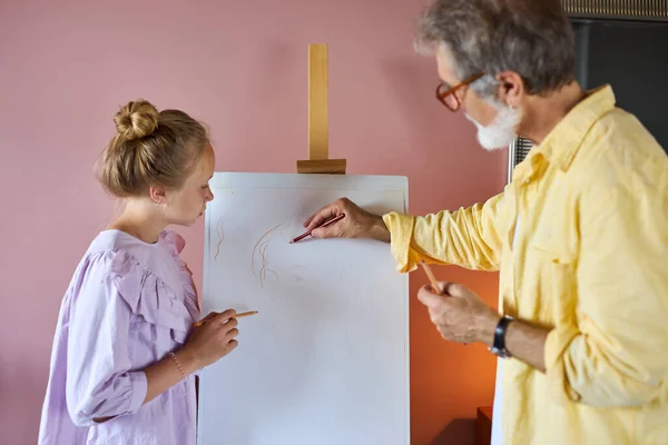 Senior man, grootvader en zijn kleindochter tekenen, samen schilderen — Stockfoto