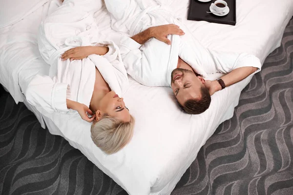 Loving married couple lie on bed in hotel, relax — Stock Photo, Image