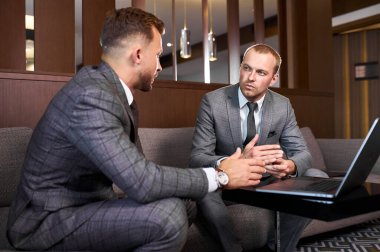 iki kendine güvenen iş adamı dizüstü bilgisayarda çalışıyor