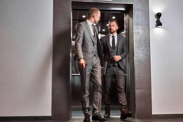 Hombres de negocios salen del ascensor — Foto de Stock