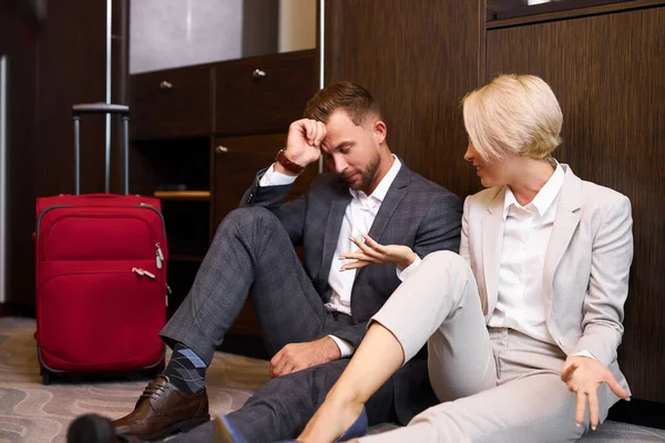 Hombre y mujer de negocios piensan cuando salen del hotel — Foto de Stock