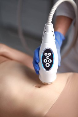 Cilt ve vücut bakımı. Kadın güzellik salonunda elektrikli masaj yaptırıyor.