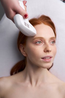 Kozmetik uzmanı kadın hasta için fotoğraf gençleştirme prosedürü uyguluyor.