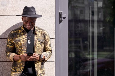 Koyu tenli genç erkek büyük kasabada yalnız yürüyor.