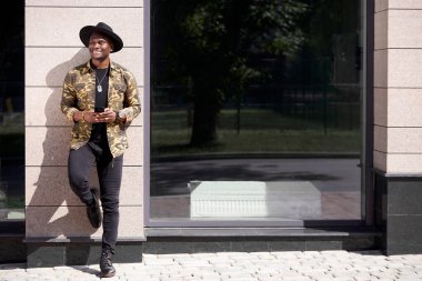 Koyu tenli genç erkek büyük kasabada yalnız yürüyor.