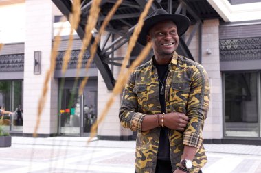 Afro-Amerikan erkek model dışarıda poz veriyor.