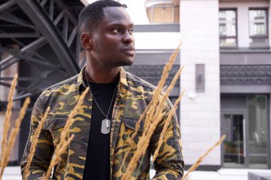 Kendine güvenen, şık giyinmiş, ciddi bir Afrikalı adamın portresi.