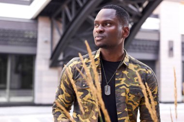 Afro-Amerikan erkek model dışarıda poz veriyor.