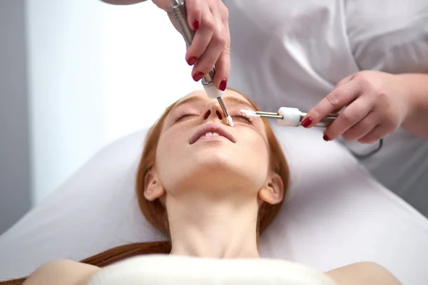 Impresionante mujer que recibe estimulante tratamiento facial eléctrico en el salón de spa — Foto de Stock