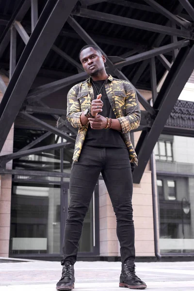 Bonito na moda preto homem posando contra moderno cidade edifício — Fotografia de Stock