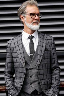 Ciddi 50-60 yıllık iş adamı dışarıda tefekkür içinde duruyor.