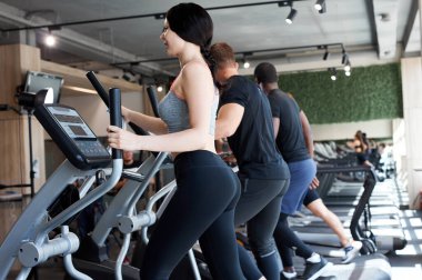 İnsanlar spor salonunda simülatör eğitimi alıyorlar.