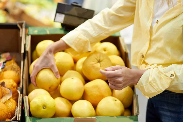 Foto close-up de mãos femininas tomando frutas frescas no supermercado — Fotografia de Stock