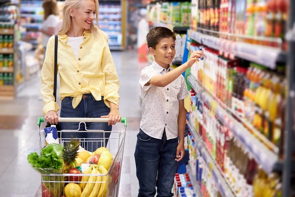 Menino criança escolher produtos com a mãe — Fotografia de Stock