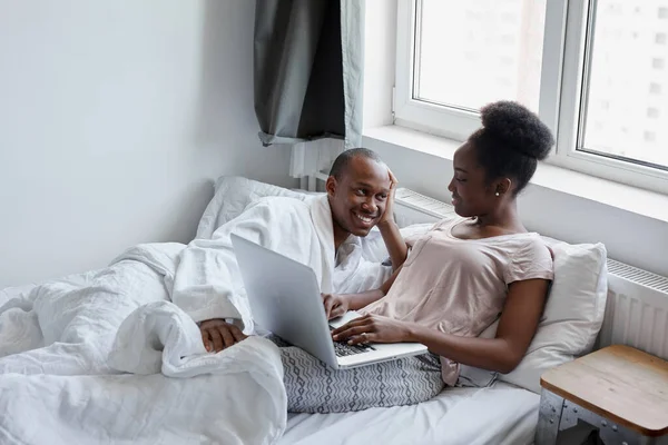 handsome african guy supports his wife during freelance work at home