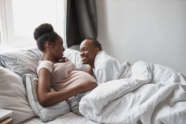 Ευτυχισμένο αφροαμερικάνικο παντρεμένο ζευγάρι ξαπλωμένο στο κρεβάτι — Φωτογραφία Αρχείου