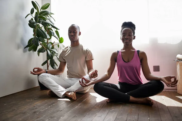 Güzel sportif çift evde birlikte meditasyon yapıyor.