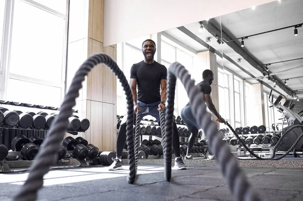 Afro atleta fazendo exercício de cordas de batalha no ginásio — Fotografia de Stock