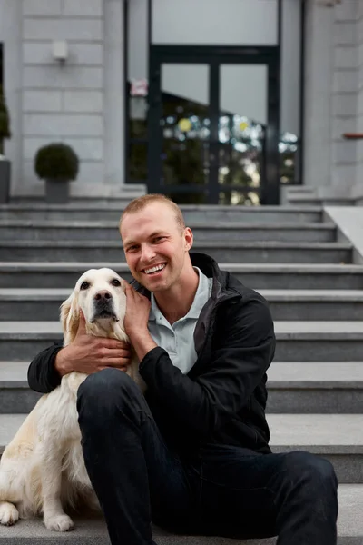 handsome man hugging his pet, a golden retriever dog