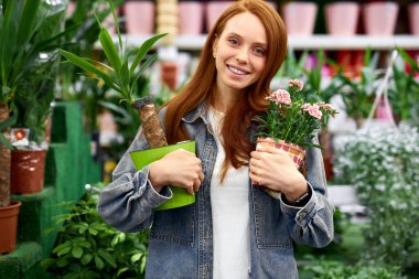 Mutlu kızıl saçlı kadın pazardan bitki almaktan hoşlanıyor.