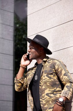 Modern yakışıklı adam yürürken telefonda konuşuyor.