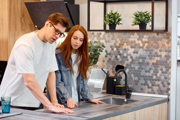 Güzel evli çift piyasada yeni bir mutfak seçiyor.