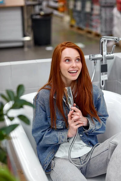 Mujer alegre disfrutar de nuevo cuarto de baño en la tienda —  Fotos de Stock