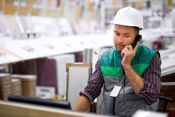 Trabalhador do armazém concentrado em conversa por telefone — Fotografia de Stock