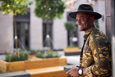 Koyu tenli genç erkek büyük kasabada yalnız yürüyor.