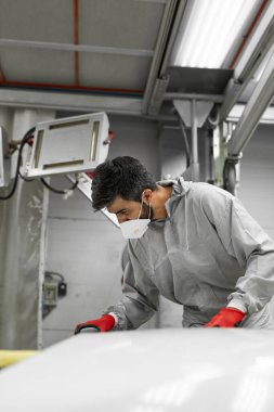 Araba, oto yıkama. Yörünge parlatıcısı olan genç bir tamirci.