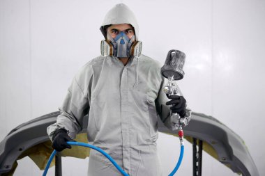 Araba boyama makinesiyle tanınmayan bir erkeğin portresi.