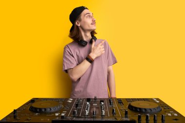 Disko adamı parti müziği yapıyor, konsolun arkasına bakıyor.