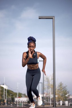 Sıska sporcu kadın şehirde koşuyor.