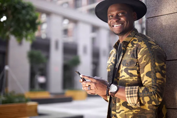 Hombre africano de moda mantenga el teléfono móvil en las manos al aire libre, charlando —  Fotos de Stock