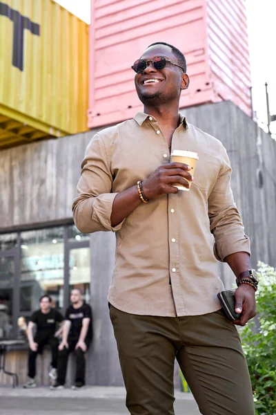 Retrato de hombre negro fresco de moda caminando al aire libre con taza de café —  Fotos de Stock