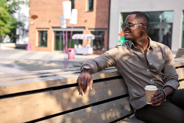Positivo negro masculino beber café al aire libre — Foto de Stock