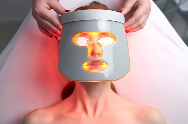 Nő LED maszkban, bőrfiatalító kezelés az esztétikai klinikán — Stock Fotó