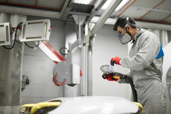 Jovem macho em corpo inteiro uniforme preparando máquina polidor — Fotografia de Stock