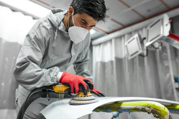 Araba, oto yıkama. Yörünge parlatıcısı olan genç bir tamirci.