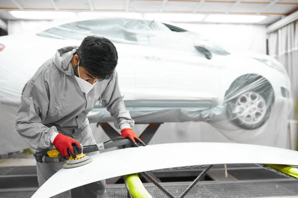 Araba, oto yıkama. Yörünge parlatıcısı olan genç bir tamirci.