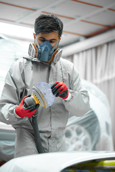 auto mechanic is concentrated on polishing of cars