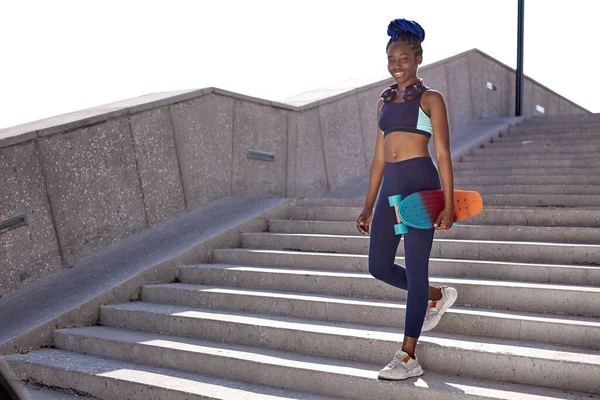 Afrikaans fitness meisje ga de trap af met skateboard — Stockfoto