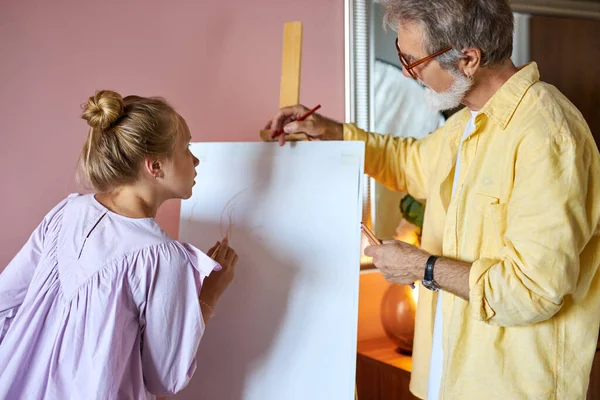 Retrato de hombre mayor, abuelo enseñanza chica pintura —  Fotos de Stock