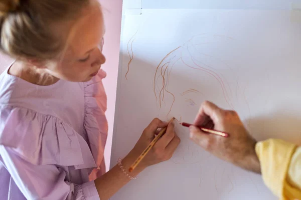 Primer plano foto de papel en caballete, niña dibujar con el profesor — Foto de Stock