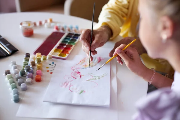 Primer plano vista de niño caucásico con el abuelo dibujo con pinceles en hoja de papel en blanco — Foto de Stock