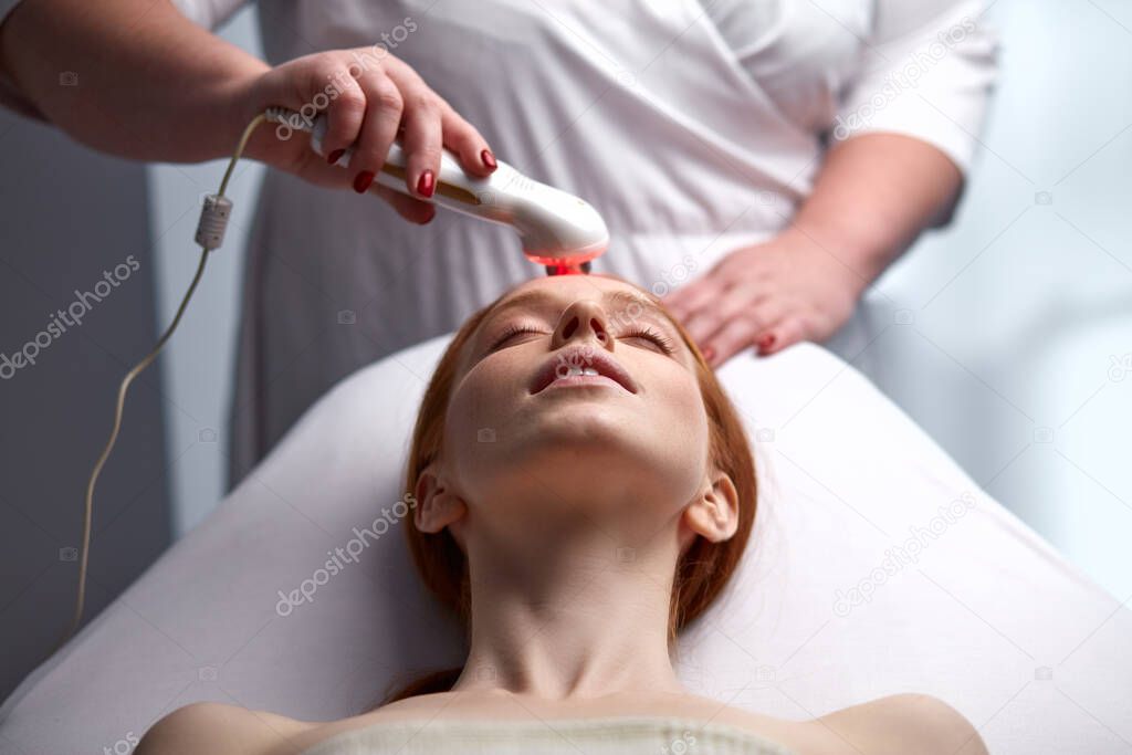 adorable young woman enjoying electric microcurrent massage